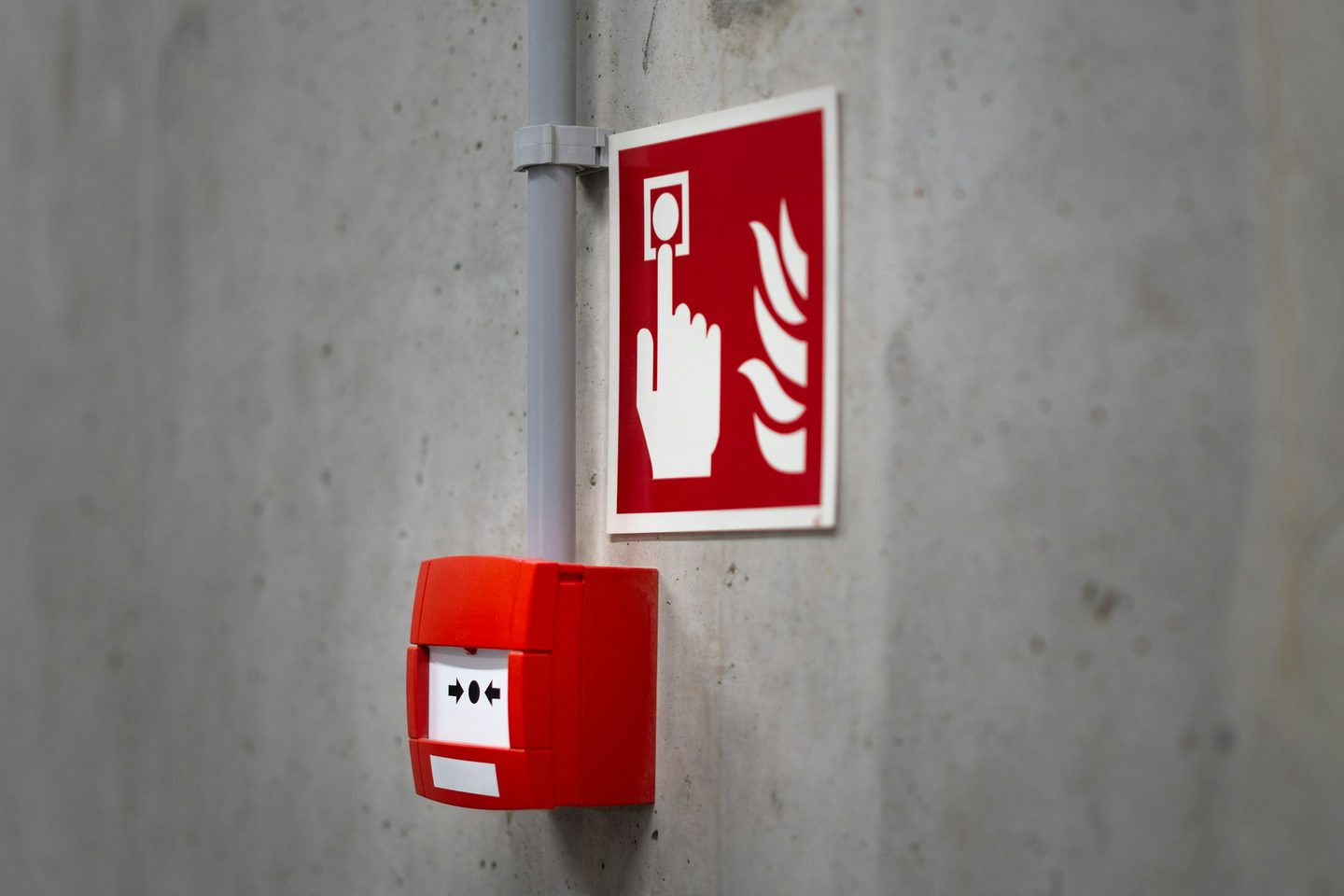 A manual fire alarm call point and sign on a wall