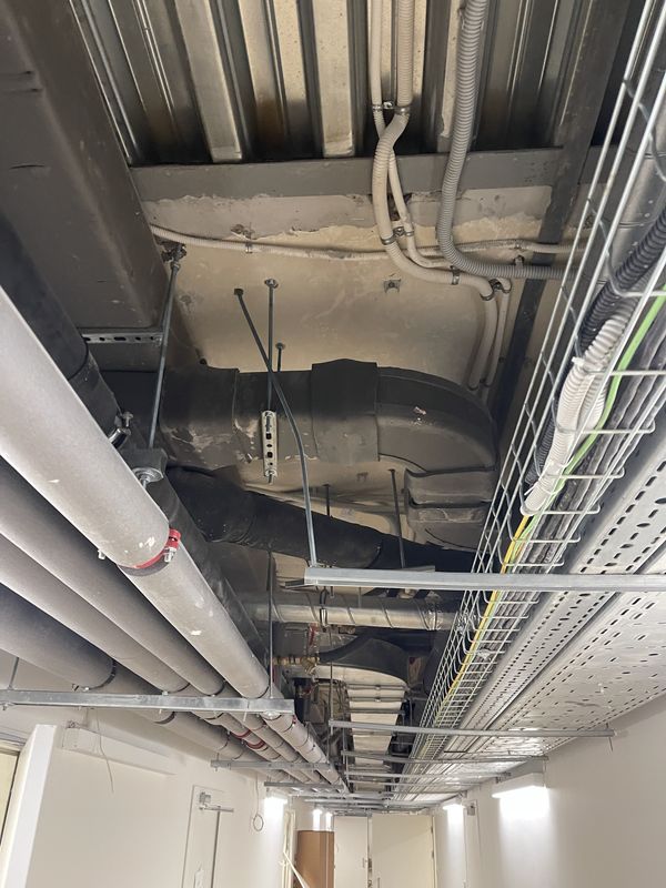 Insulated refrigerant lines, ducts and cable trays under the ceiling