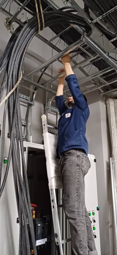 Laying cables on the trays above the switchboards